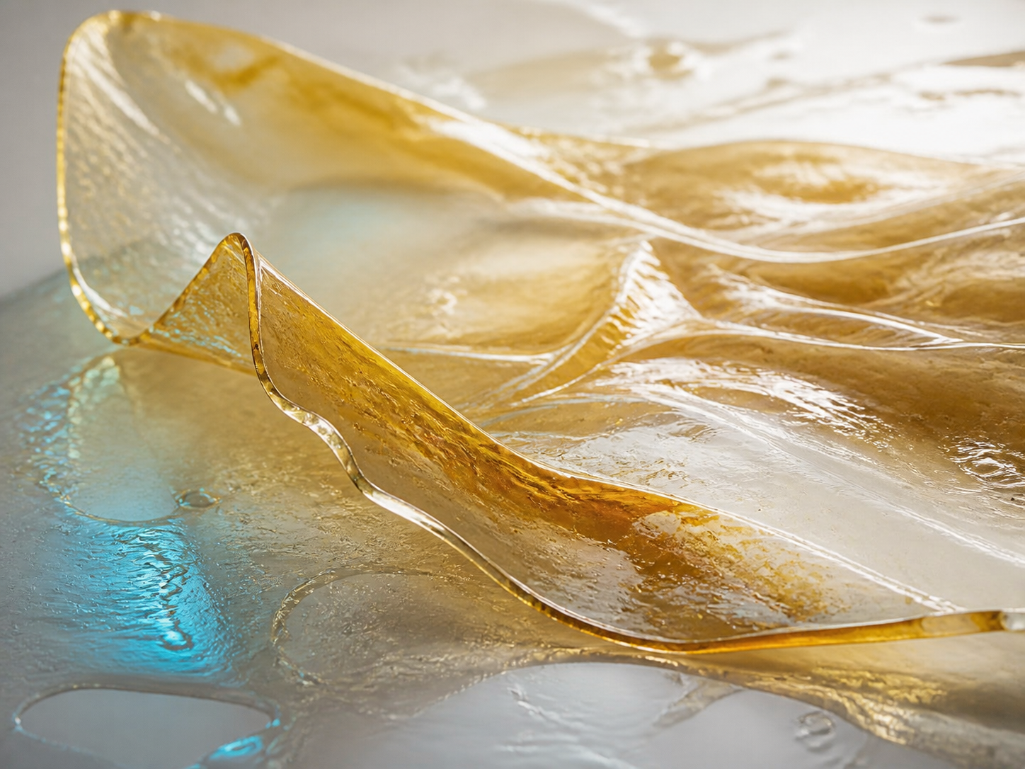Transparente, glänzende Lackhaut in Amber- und Cyanreflexen